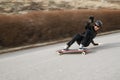 Young man in helmet is going to slide, slide with sparks on a longboard on the asphalt Royalty Free Stock Photo