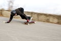 Young man in helmet is going to slide, slide with sparks on a longboard on the asphalt Royalty Free Stock Photo