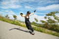 Young man in helmet is going to slide, slide with sparks on a longboard on the asphalt Royalty Free Stock Photo