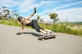 Young man in helmet is going to slide, slide with sparks on a longboard on the asphalt Royalty Free Stock Photo