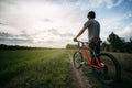 Man with bicycle at country road enjoying sunset Royalty Free Stock Photo