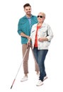 Young man helping blind person with long cane on white Royalty Free Stock Photo