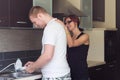 Young man helping girlfriend to do dishes