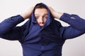 Young man hiding in a blue shirt hiding his face