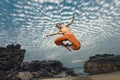 Young man high jumping on beach