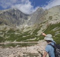 Young man hiker looking and point to mountain Peak Lomnicky stit 2 634 m at Summer, the highest mountain peaks in the Royalty Free Stock Photo