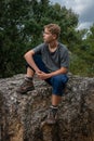 Young man hiker resting  on large rock in the french countryside ,adventure walking holiday Royalty Free Stock Photo