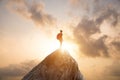 Young man hiking and standing alone on top of the mountain with backpack looking beautiful view sunset. Travel lifestyle Royalty Free Stock Photo