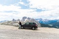 Young handsome man with hiking stuff use phone near his car on mountains background Royalty Free Stock Photo