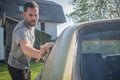 Man cleaning vintage car windows