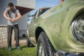 Man cleaning vintage car windows