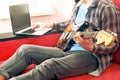 Casually dressed young man with guitar playing songs in the room at home. Online guitar lessons concept. Male guitarist practicing Royalty Free Stock Photo