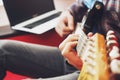 Casually dressed young man with guitar playing songs in the room at home. Online guitar lessons concept. Male guitarist practicing Royalty Free Stock Photo