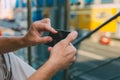 Young man hipster is holding a smartphone. A man writes a message, looks at the Internet news on his phone. Urban fast life