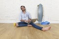 Young man in hipster modern casual style look sitting on living room home floor working on laptop Royalty Free Stock Photo