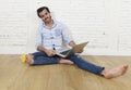 Young man in hipster modern casual style look sitting on living room home floor working on laptop Royalty Free Stock Photo