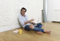 Young man in hipster modern casual style look sitting on living room home floor working on laptop Royalty Free Stock Photo