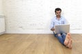 Young man in hipster modern casual style look sitting on living room home floor working on laptop Royalty Free Stock Photo
