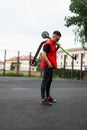 Young man hipster posing with an electric scooter. Guy in trendy red-black denim clothes in sunglasses in sneakers with a scooter Royalty Free Stock Photo