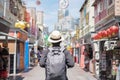 Young man hipster traveling with backpack and hat, happy Solo traveler walking at Chinatown street market in Singapore. landmark