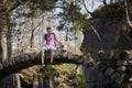 Young man with his dog sitting old stone bridge in beautiful nature Royalty Free Stock Photo