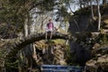 Young man with his dog sitting old stone bridge in beautiful nature Royalty Free Stock Photo