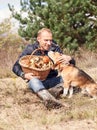 Young man with his dog on sunny autumn forest glade with mushroo Royalty Free Stock Photo