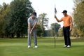 Young man with his friend playing golf in golf course