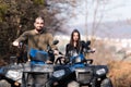 Young man with his girlfriend driving a blue off-road quad bike in a rural area in daylight Royalty Free Stock Photo