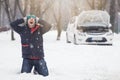 Frustrated driver next to broken car. Winter season road trip problems and assistance concept. Royalty Free Stock Photo