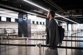 Young man with his luggage and backpack using smartphone while waiting for airline flight in the international airport Royalty Free Stock Photo