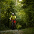 Young man with his mountain bike going for a ride past the city limits in a lovely forest Royalty Free Stock Photo