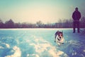 Young man with his running dog on snow Royalty Free Stock Photo