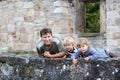 Young man and his two little boys standing behind wall of old Ge Royalty Free Stock Photo