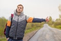 Young man hitchhiking. passenger on the road near the curb. guy catches a taxi cab with thumb up gesture.