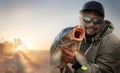 Young man hold big carp in his hands. Royalty Free Stock Photo