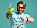 Young man hold blue hawaiian margarita cocktail drink juice happy smiling pointing one finger Royalty Free Stock Photo