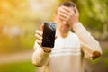 Young man hold broken smartphone screen stressed with hand on head, shocked with shame and surprise face, angry and frust