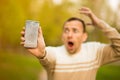 Young man hold broken smartphone screen stressed with hand on head, shocked with shame and surprise face, angry and frust