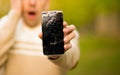 Young man hold broken smartphone screen stressed with hand on head, shocked with shame and surprise face, angry and frust