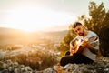 Young man holding acoustic guitar and looking to sunset.Searching inspiration.Music creator.New artist.Musical talent.