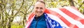 Young man holding american national flag to the sky with two hands Royalty Free Stock Photo