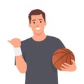 Young man holding basketball ball over white background smiling with happy face looking and pointing to the side with thumb up Royalty Free Stock Photo