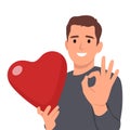Young man holding big love red heart with ok sign. Valentine day concept Royalty Free Stock Photo