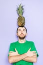 Young man holding big pineapple on his head Royalty Free Stock Photo