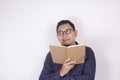 Young Man Holding Book, Thinking Expression Royalty Free Stock Photo