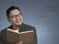Young Man Holding Book, Thinking Expression Royalty Free Stock Photo