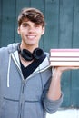 Young man holding books outside with headphones Royalty Free Stock Photo