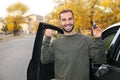 Young man holding car key near auto. Royalty Free Stock Photo