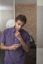 Young man Holding Cellphone In Office Royalty Free Stock Photo